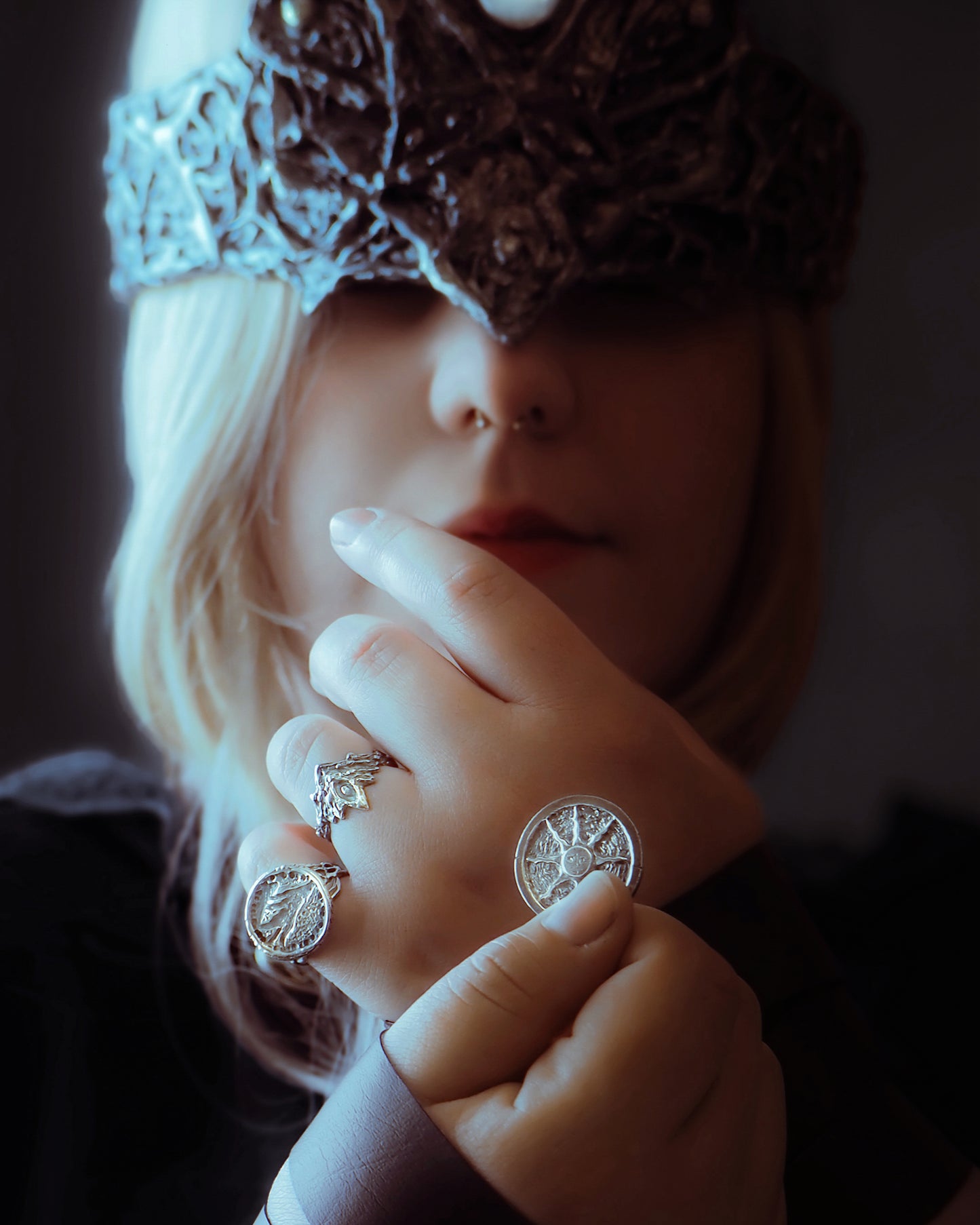 Close-up of a person wearing multiple rings with intricate designs.