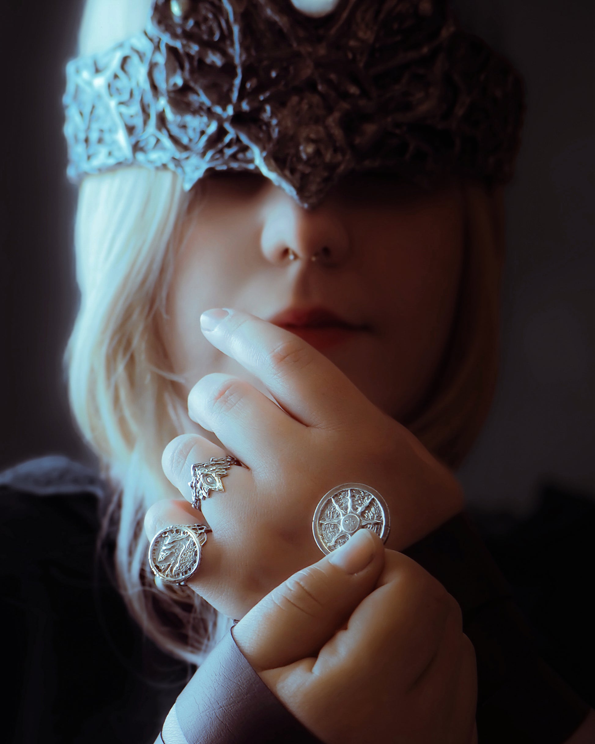 Close-up of a person wearing multiple rings with intricate designs.