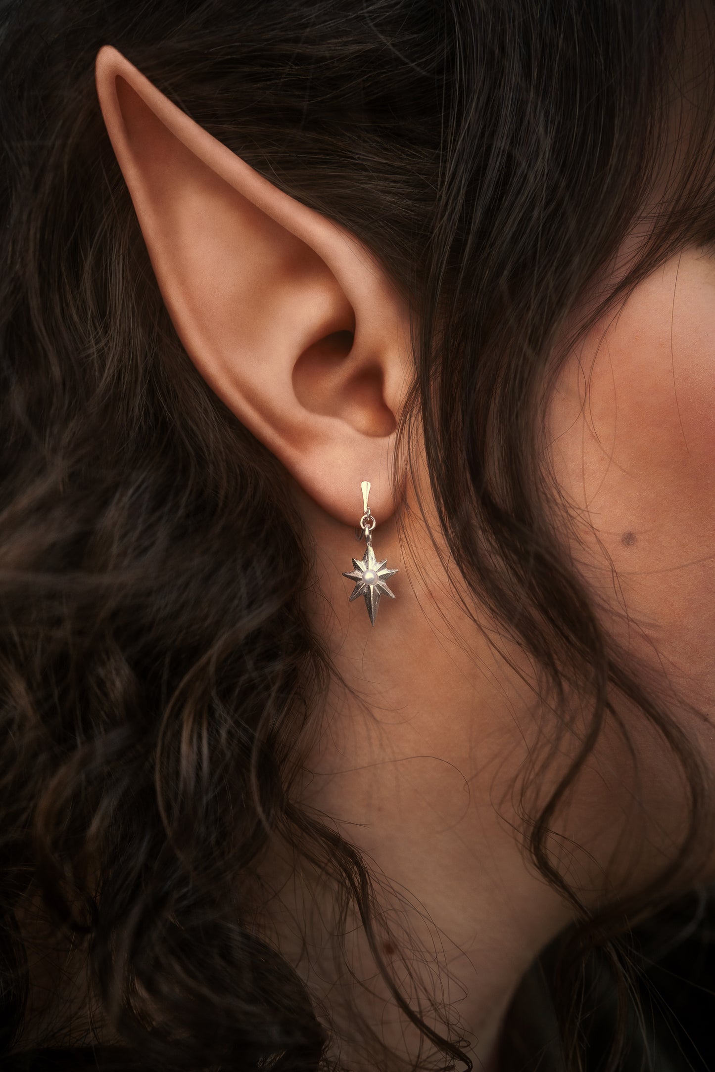 Side view of an elvish woman wearing a hand-sculpted 'Lady of Light' earring.