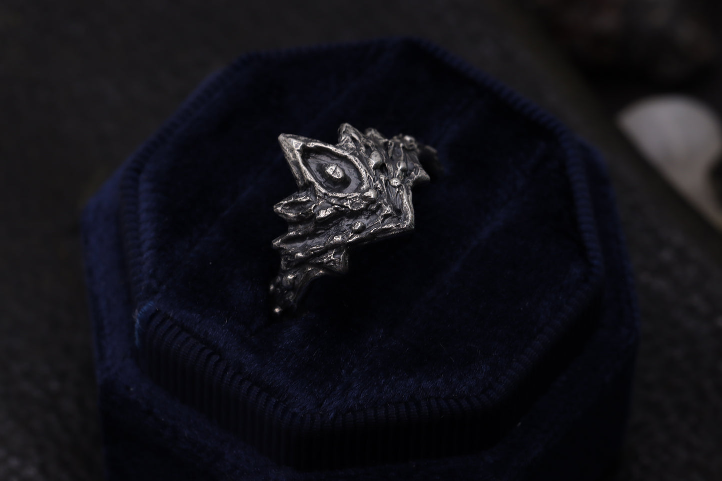 Silver Firekeepers Ring on a dark blue textured surface