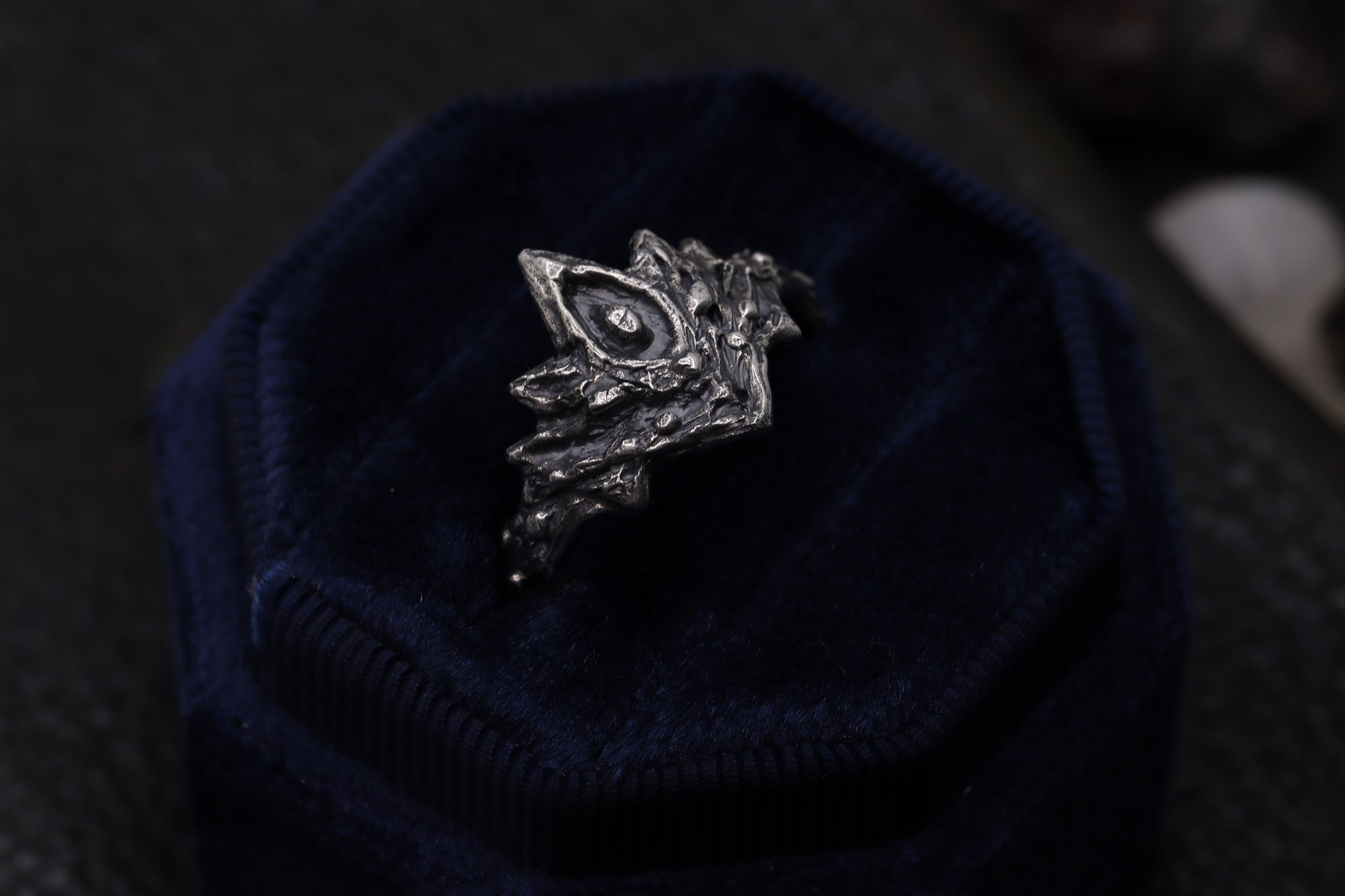 Silver Firekeepers Ring on a dark blue textured surface